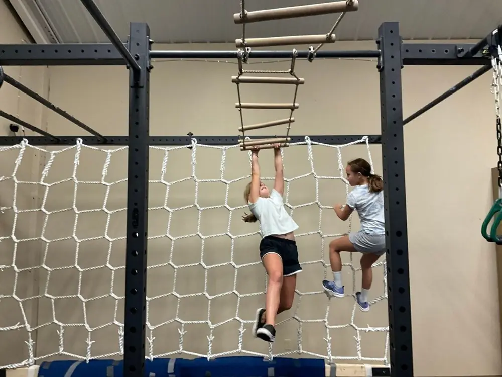 Kids climbing the rope ladder on the 50-foot Ninja rig