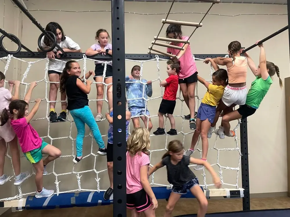 Kids climbing the cargo net on the Ninja rig